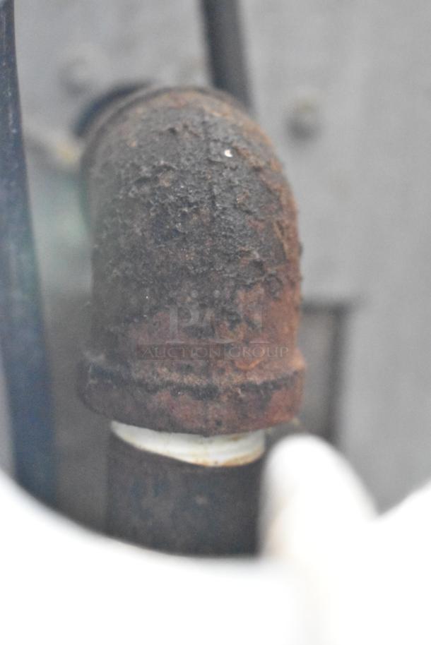 Alt text: Rusty metal pipe or fitting, close-up view, showing signs of corrosion.