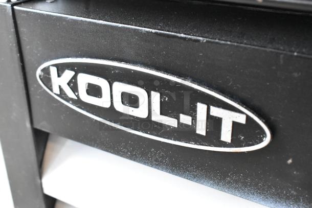 Kool-It KGF-72 logo on black metal surface, showcasing commercial cooler branding.
