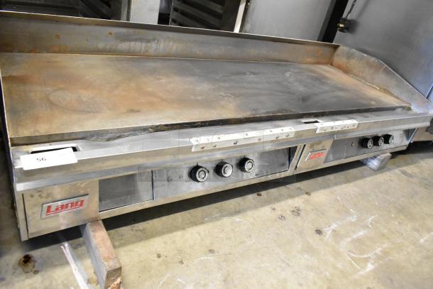 Lang stainless steel commercial countertop flat top griddle with knobs. Some wear visible. Lang brand label present.