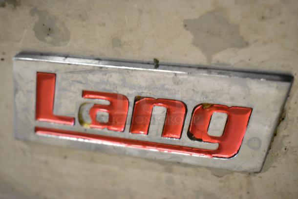 Lang stainless steel countertop flat top griddle nameplate, showcasing the Lang logo in red on a metallic surface.