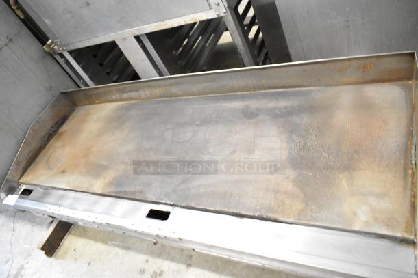 Lang stainless steel commercial countertop flat top griddle, used condition, some surface wear and discoloration visible.