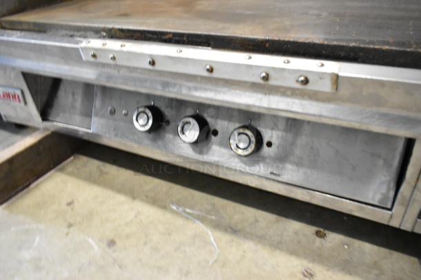 Lang stainless steel commercial countertop flat top griddle with three control knobs. Used condition.