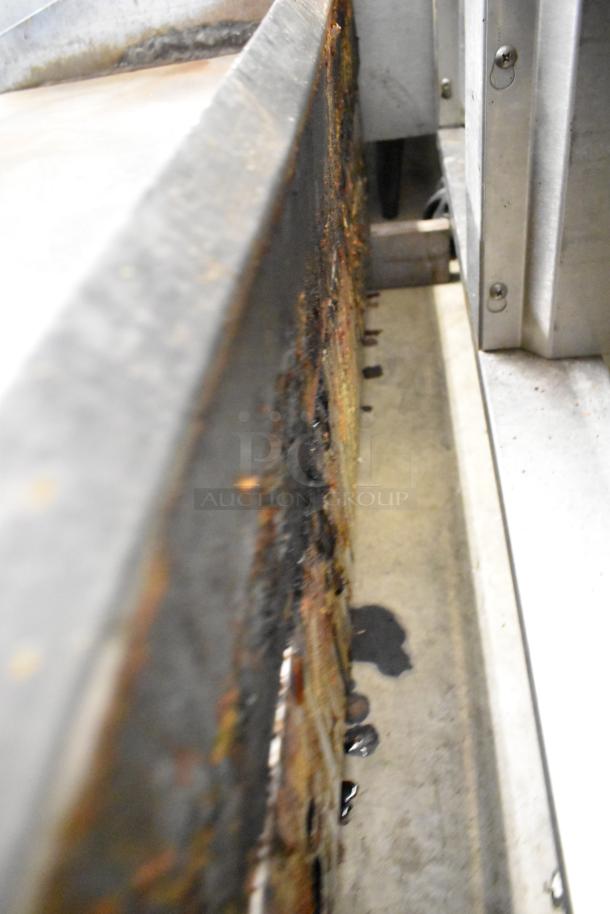 Lang stainless steel commercial flat top griddle, showing side view with signs of wear and rust, indicating used condition.