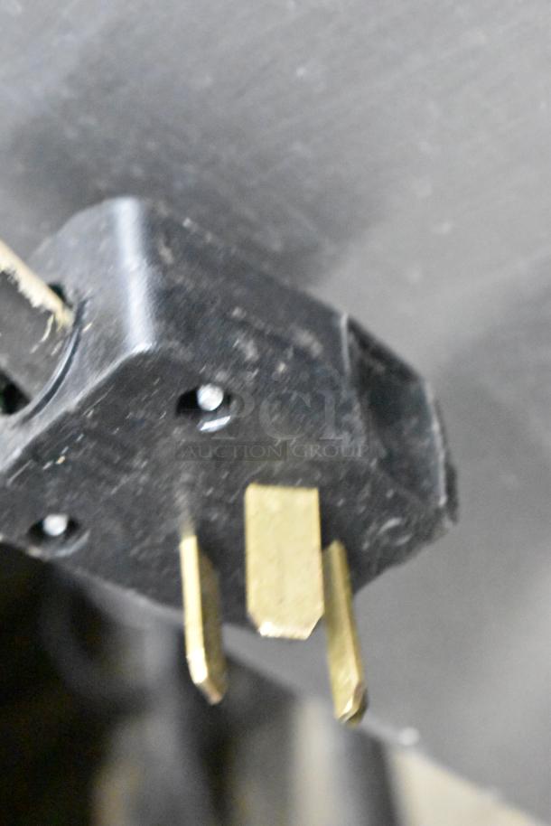 Close-up of an electrical plug for Moffat E89AMS Turbofan convection ovens, showing three prongs.
