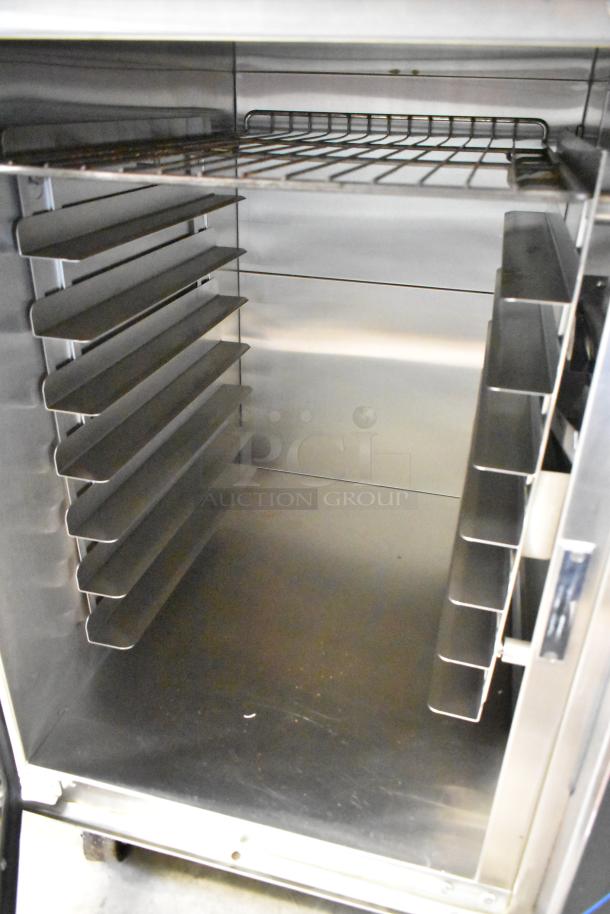 Moffat E89AMS Turbofan stainless steel electric convection oven interior with metal racks and casters.