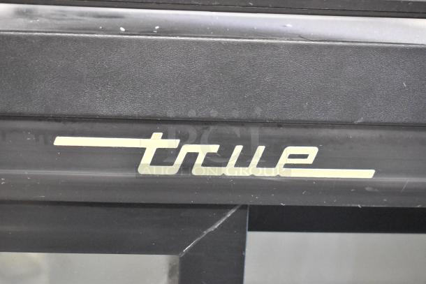 True GDM-41SL-54-LD cooler logo. Black metal surface with cream-colored "true" text. Commercial reach-in cooler model.