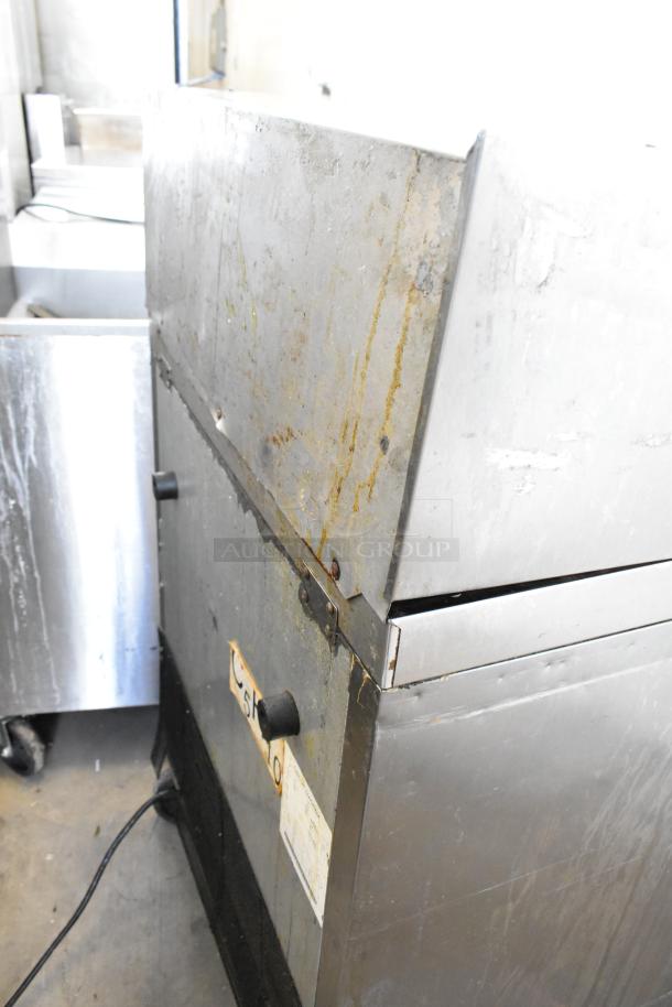 Atosa MGF8305GR stainless steel prep table in used condition, showing rust and wear. Features commercial casters. 115V, 1 phase.