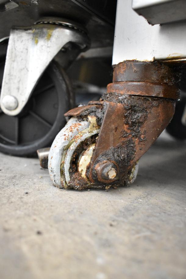 Alto Shaam 750-S holding cabinet caster shows signs of rust, indicating wear on stainless steel commercial unit.