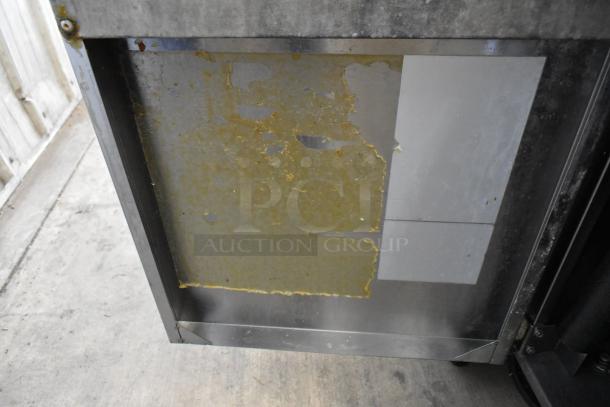 Cook Rite stainless steel commercial deep fryer with two metal baskets, mounted on casters. Worn surface visible.