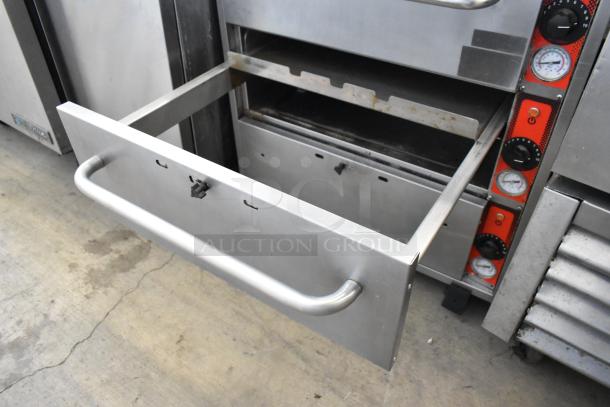 Vulcan stainless steel commercial warming drawer, three drawers, on casters. Visible temperature controls, open drawer.