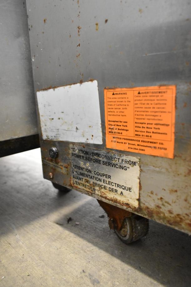 Vulcan stainless steel commercial 3-drawer warming drawer on casters, visible rust and warning labels, fair condition.