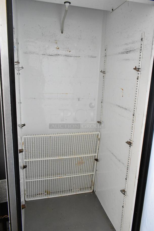 True T-23 stainless steel single door reach-in cooler, interior view, showing shelves and light wear. 115 Volts, on casters.