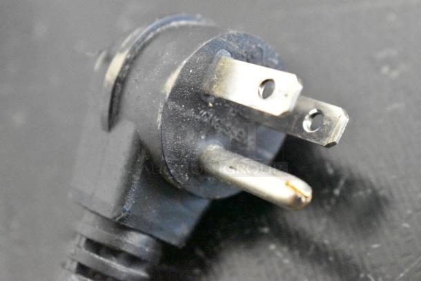 Close-up of a black electrical plug for a 2020 Hisense RR44D6ASE Mini Cooler, showing details of the prongs.