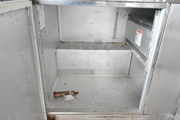 Traulsen ULT60 stainless steel 2-door undercounter freezer, interior view, some wear, labels visible. 115 volts, 1 phase.