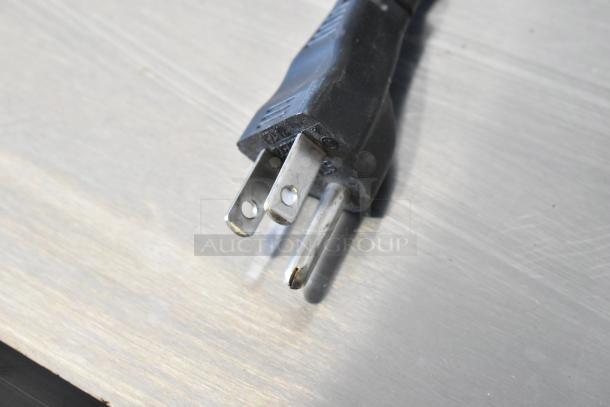 Close-up of a metal mini cooler merchandiser's power plug. Black three-prong plug for 115 volts, 1 phase connection.
