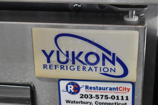 Yukon YUC-72F stainless steel 3-door undercounter freezer with commercial casters. Features visible brand and model labels.