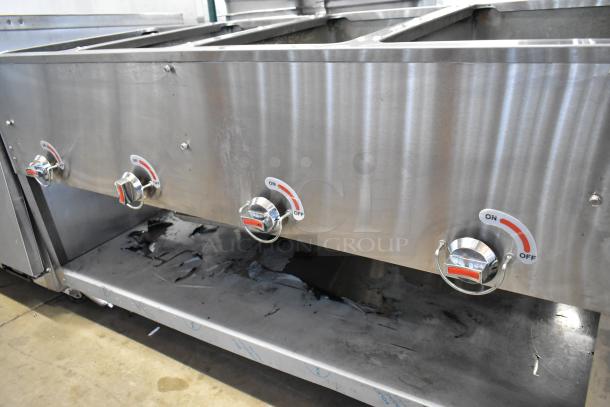 Stainless steel commercial gas-powered 4 burner steam table with under shelf, showing control knobs in good condition.