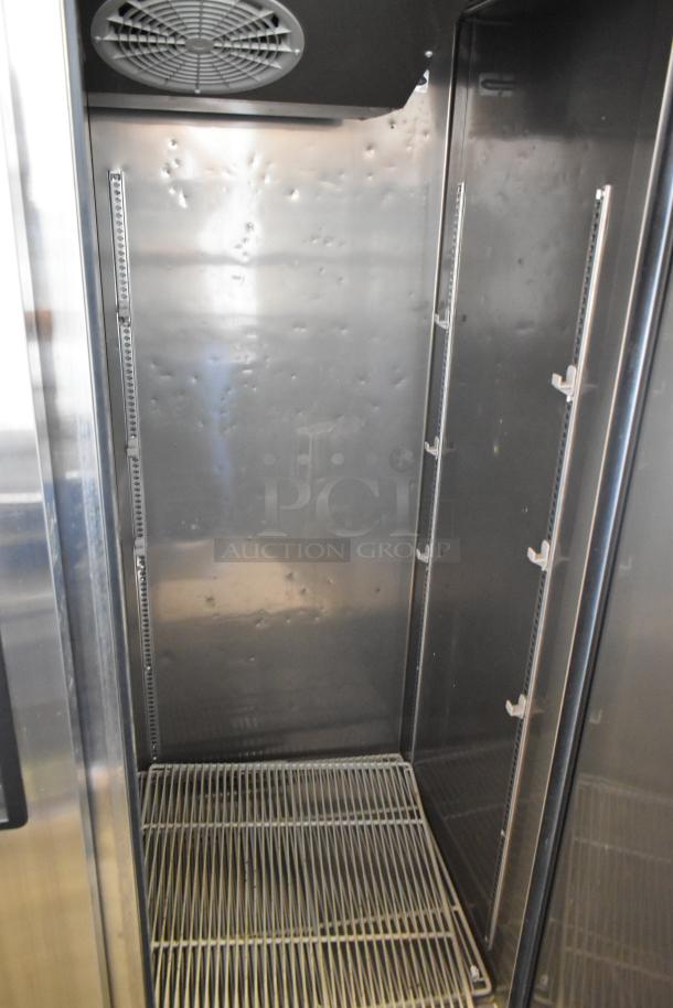 Turbo Air M3F47-2 stainless steel commercial freezer interior with poly coated racks, showing some wear and commercial casters.