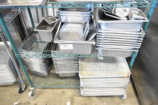 Two-tier lot with metal baking pans and stainless steel drop-in bins on a wheeled rack. Tag marked "116 QTY." Variety of sizes.