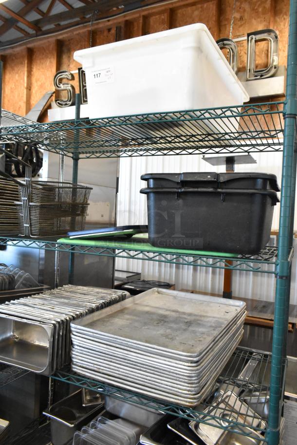 Three-tier shelving with metal baking pans, stainless steel drop-in bins, and poly bus bins. Auction tag number 117 visible.