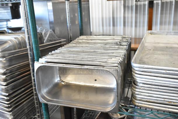 Three-tier lot featuring metal baking pans, stainless steel drop-in bins, and poly bus bins on shelving.