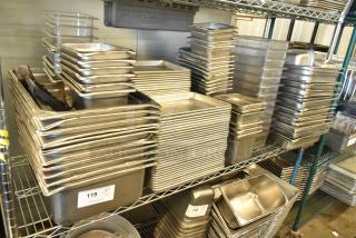 Stainless steel drop-in bins, metal baking pans, and poly bins on a shelf, labeled for auction, in good condition.