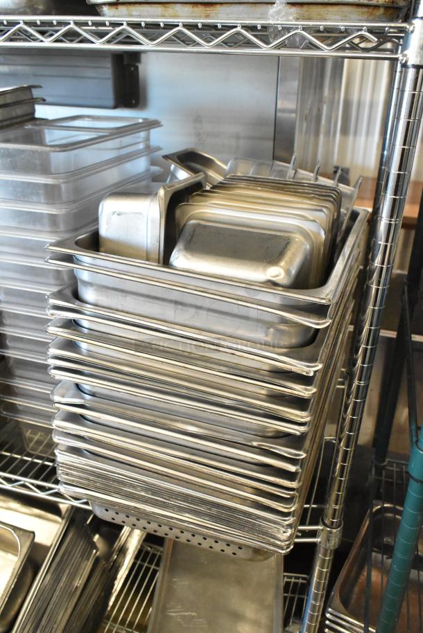 Tiered lot of kitchen items, featuring stainless steel drop-in bins, metal baking pans, and poly drop-in bins. Ideal for catering.