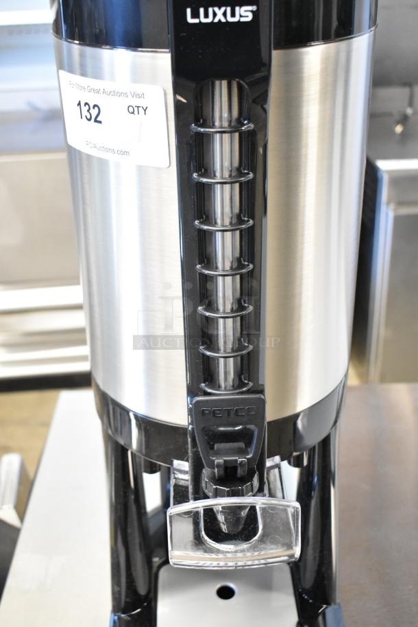 BRAND NEW 2025 Fetco Luxus LGD-20 2 Gallon Coffee Dispenser with Stand, stainless steel, minor scratches, auction label visible.