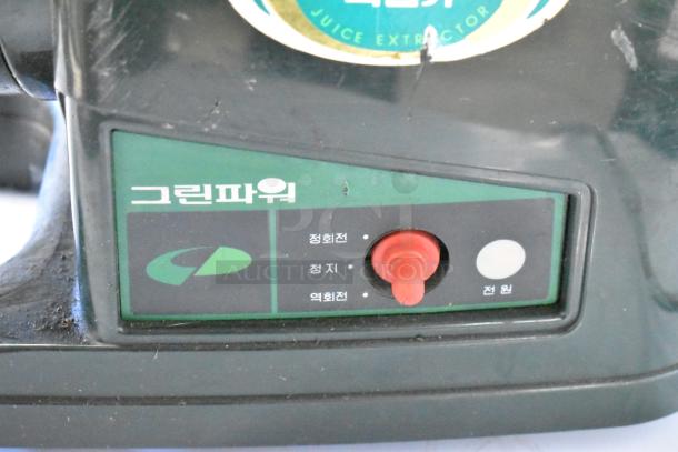 Countertop juice extractor machine, green control panel, red switch, labeled in Korean, slight wear.