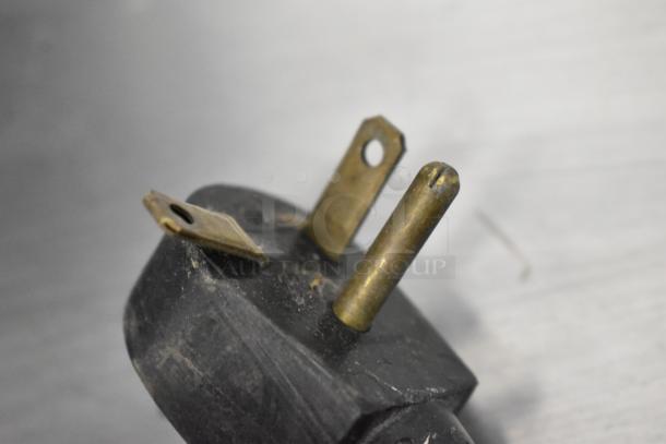 Close-up of a power plug from a Silver King SKF27 undercounter freezer, showing prongs and surface wear.