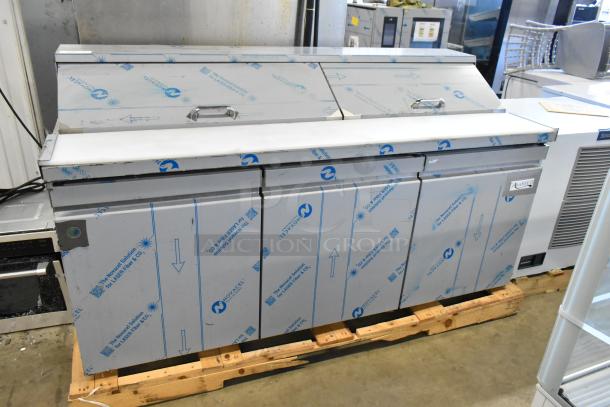 BRAND NEW 2025 Avantco 447APST72 72" 3 Door Stainless Steel Refrigerated Prep Table, shown with protective film, on a pallet.