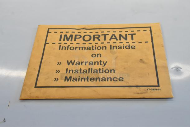 Scratched Scotsman MC1030MA-32A ice machine manual envelope on a table, highlighting warranty, installation, and maintenance info.