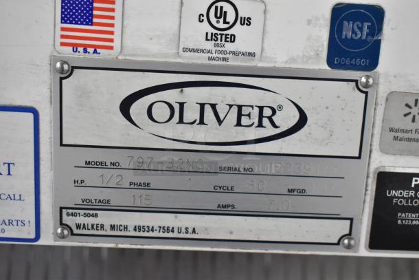 Oliver 797-32NC metal bread loaf slicer label showing model, serial number J152391, voltage 115, NSF, and UL certifications.