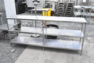 Stainless steel table with two under shelves, excellent condition, durable surface, suitable for kitchen or storage use.