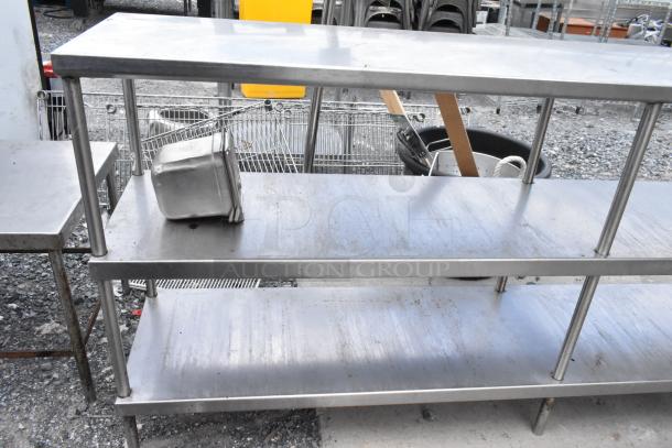 Stainless steel table with two under shelves, used condition, featuring durable construction and ample storage space.