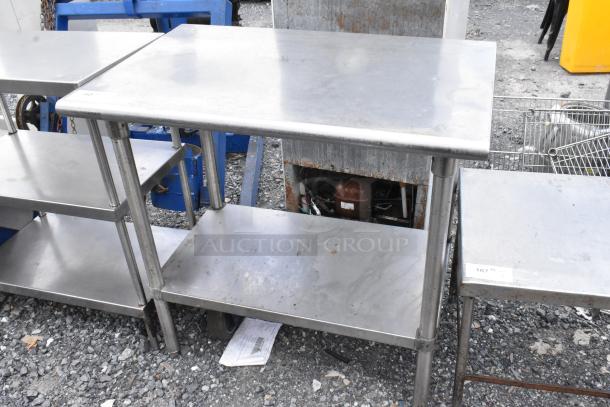 Stainless steel table with metal under shelf, showing surface wear; ideal for kitchen or industrial use. Measures approx. 48"x24"x34".