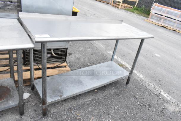 Stainless steel table with metal under shelf, used condition, visible wear on surface, ideal for industrial use.
