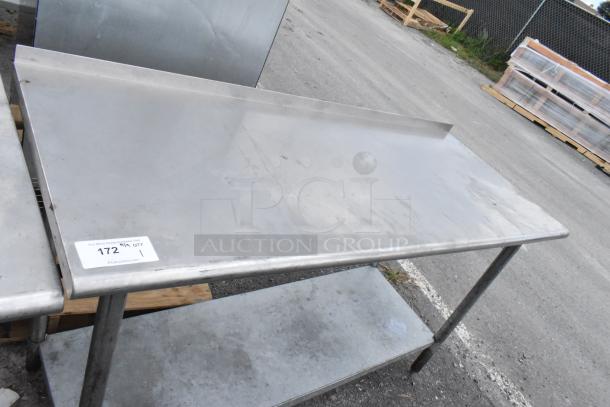 Stainless steel table with metal under shelf; industrial use; visible wear; inventory tag "172". Perfect for kitchens or workshops.