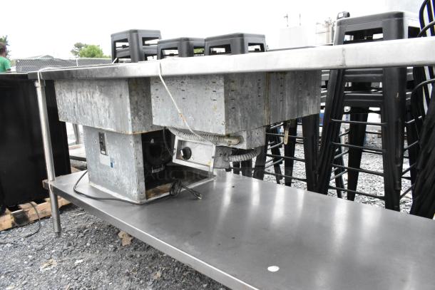 Stainless steel 2 well food warmer station with under shelf, visible signs of wear and electrical components.