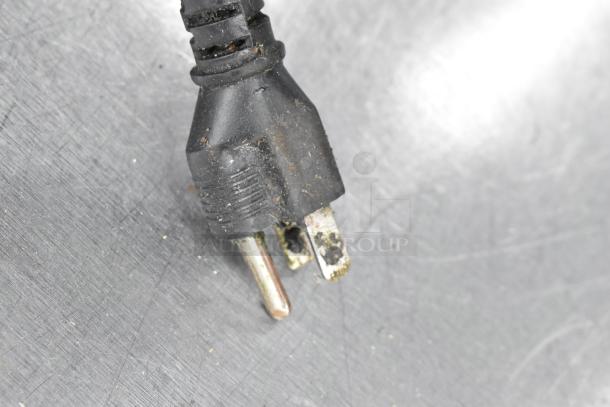 Close-up of a used electrical plug from a stainless steel 2 well food warmer station with visible wear.