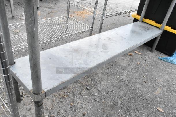Stainless steel table with a metal under shelf, showing slight wear. Durable design ideal for storage or workspace.