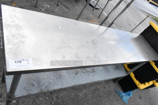 Stainless steel table with metal under shelf, showing signs of wear. Auction label indicates lot 179.