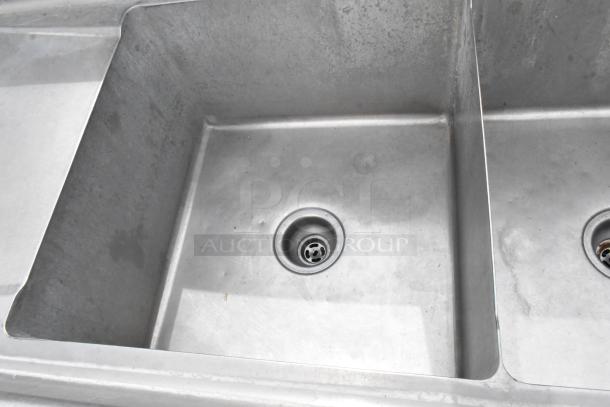 Stainless steel 3-bay sink with dual drain boards, showing clean basins and smooth surface, ideal for commercial use.