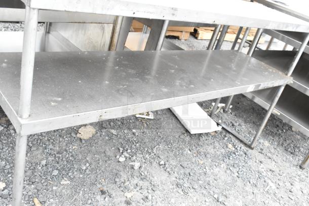 Stainless Steel 2 Tier Over Shelf, industrial-grade, sturdy design, some surface wear, suitable for kitchen or workspace.