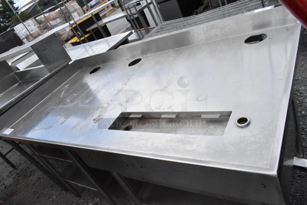 Stainless steel commercial soda station with under shelves, featuring cutouts for dispensers on a durable countertop.