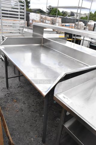 Stainless steel commercial table, durable, spacious surface, rear and side splash guards, sturdy legs, used condition.
