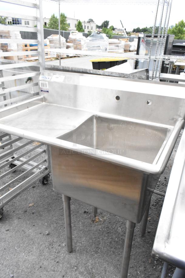 Yukon stainless steel commercial single bay sink with left side drain board, clean condition, visible brand label.