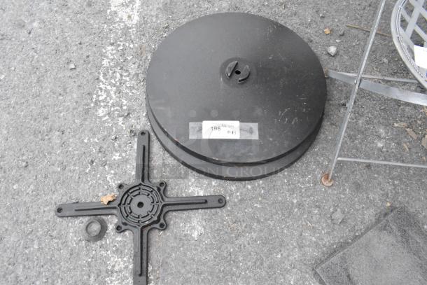 Lot of 2 table base feet plates and 1 top base piece. Plate has label "196 QTY". Black finish, minor wear visible.