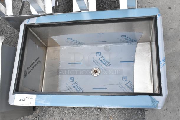 Stainless steel commercial drop-in ice bin, unused with protective film, featuring embedded drain, label indicates "Pregis PolyMask."