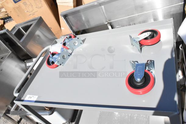 Gray metal 2-tier cart with commercial casters, new with visible minor scratches and dents; auction item labeled "215".